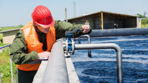 Engineer operating valve at water treatment facility