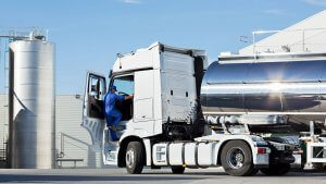 Truck loading and unloading from a nearby silo.